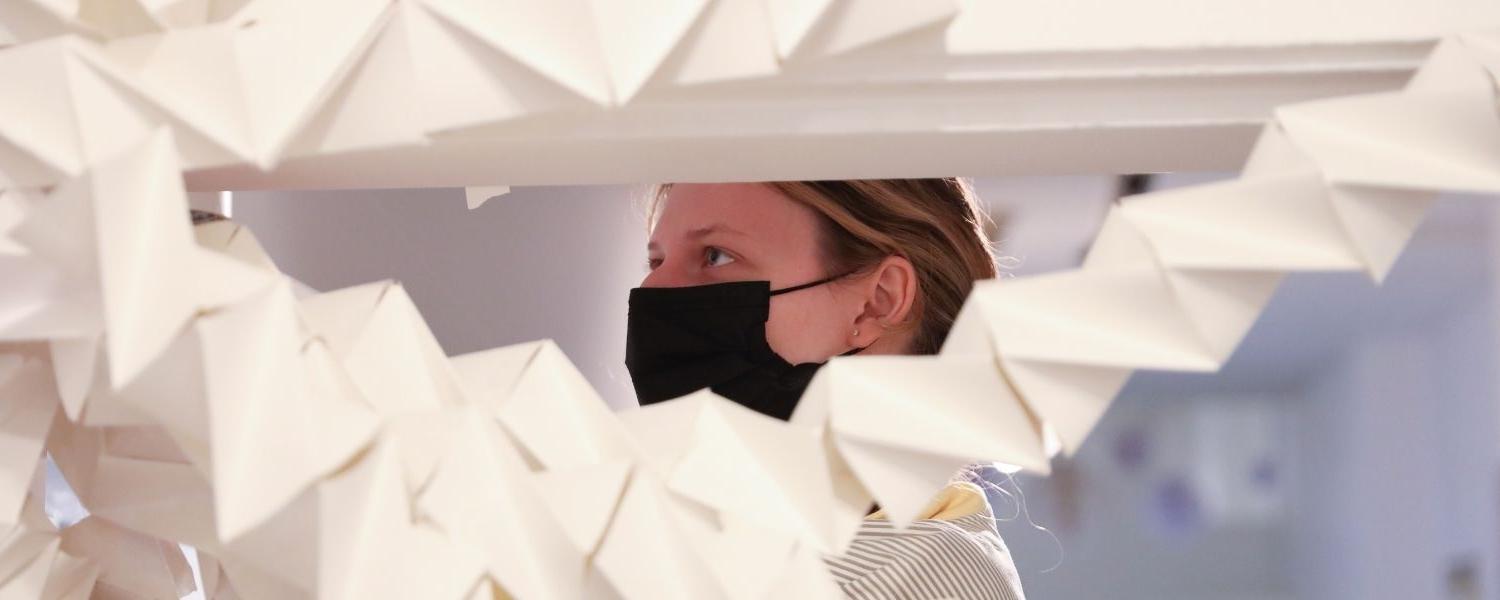 An art student works on a paper project in the Art Center.